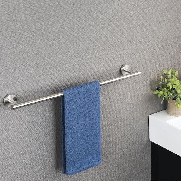 A person reviewing instructions for a 30-inch brushed nickel towel rack installation.