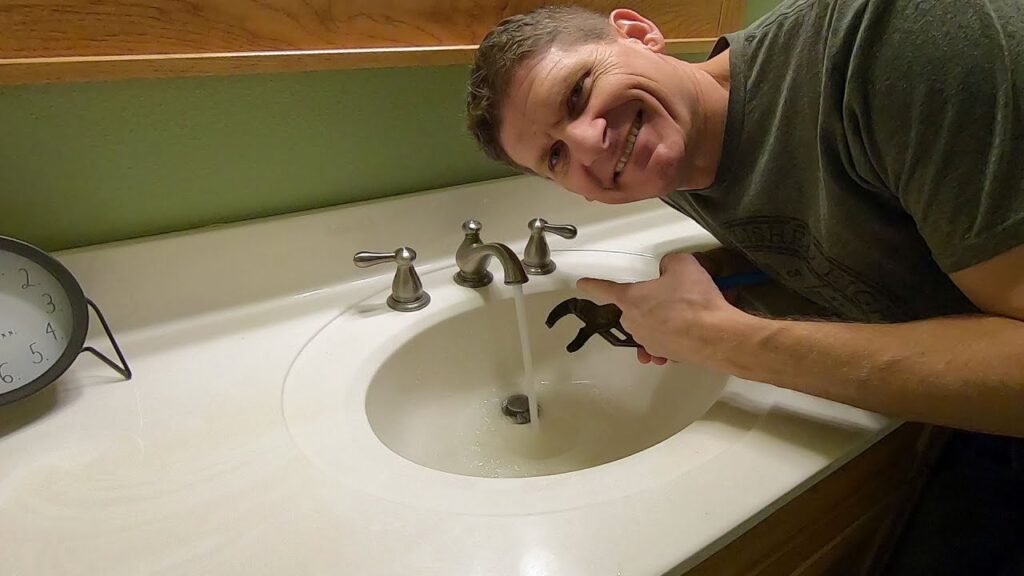A modern bathroom faucet with a steady stream of water in a bright bathroom.