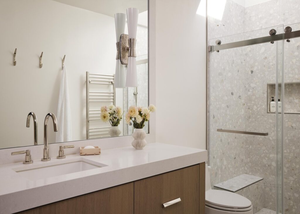A modern, bright bathroom with a small mirror creating an illusion of space.
