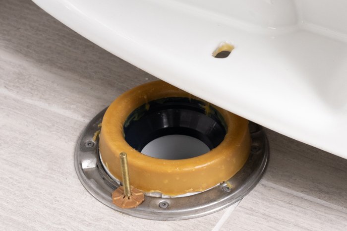 A professional plumber's toolkit placed near a clean white toilet in a bathroom.