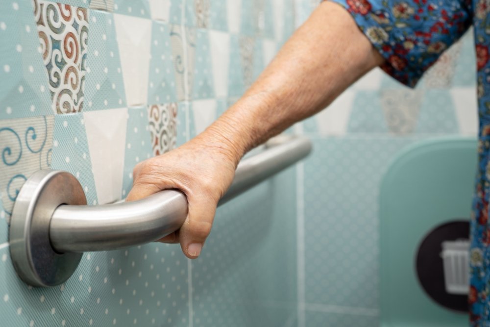 A low-profile bathroom rug with beveled edges lying flat on a bathroom floor.