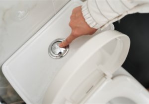 Non-flushable wet wipes sitting in the bottom of a white toilet bowl.