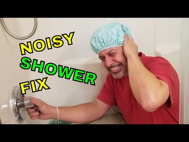 Hands carefully removing a plastic shower mixing cartridge during a plumbing repair.