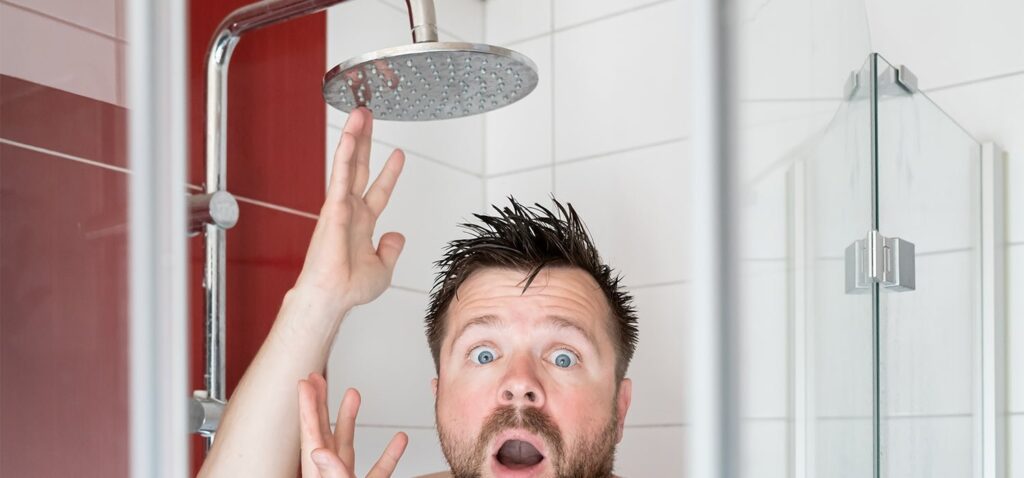 A modern chrome showerhead in a bright bathroom ready for maintenance and repair.