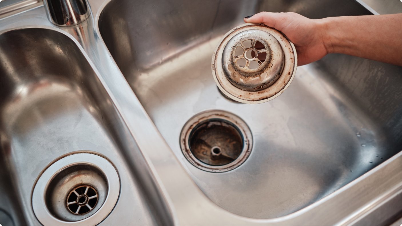 Organized bathroom essentials displayed on a shelf representing tips for bathroom sink maintenance.