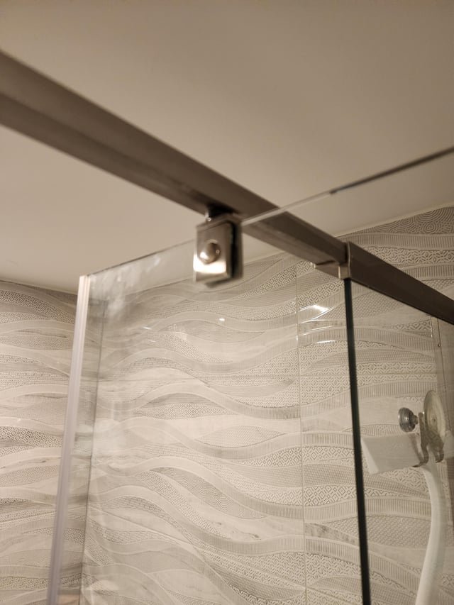 Essential tools for removing a pivot shower door are neatly laid out on a vanity.