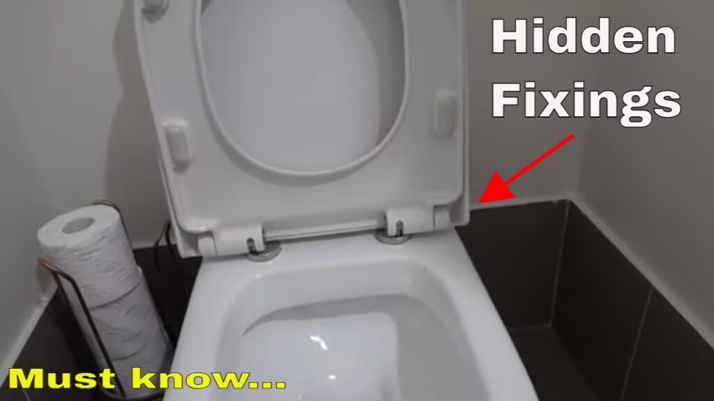A person installs a new toilet seat using a screwdriver in a bright bathroom.