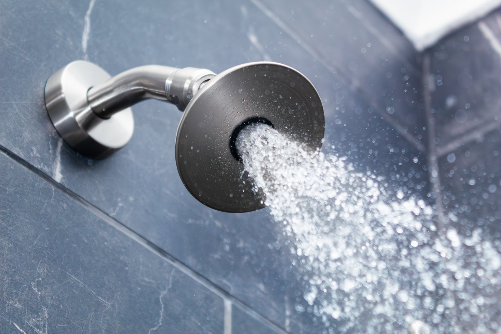 Mineral scale buildup on a showerhead nozzle causing reduced water flow efficiency.
