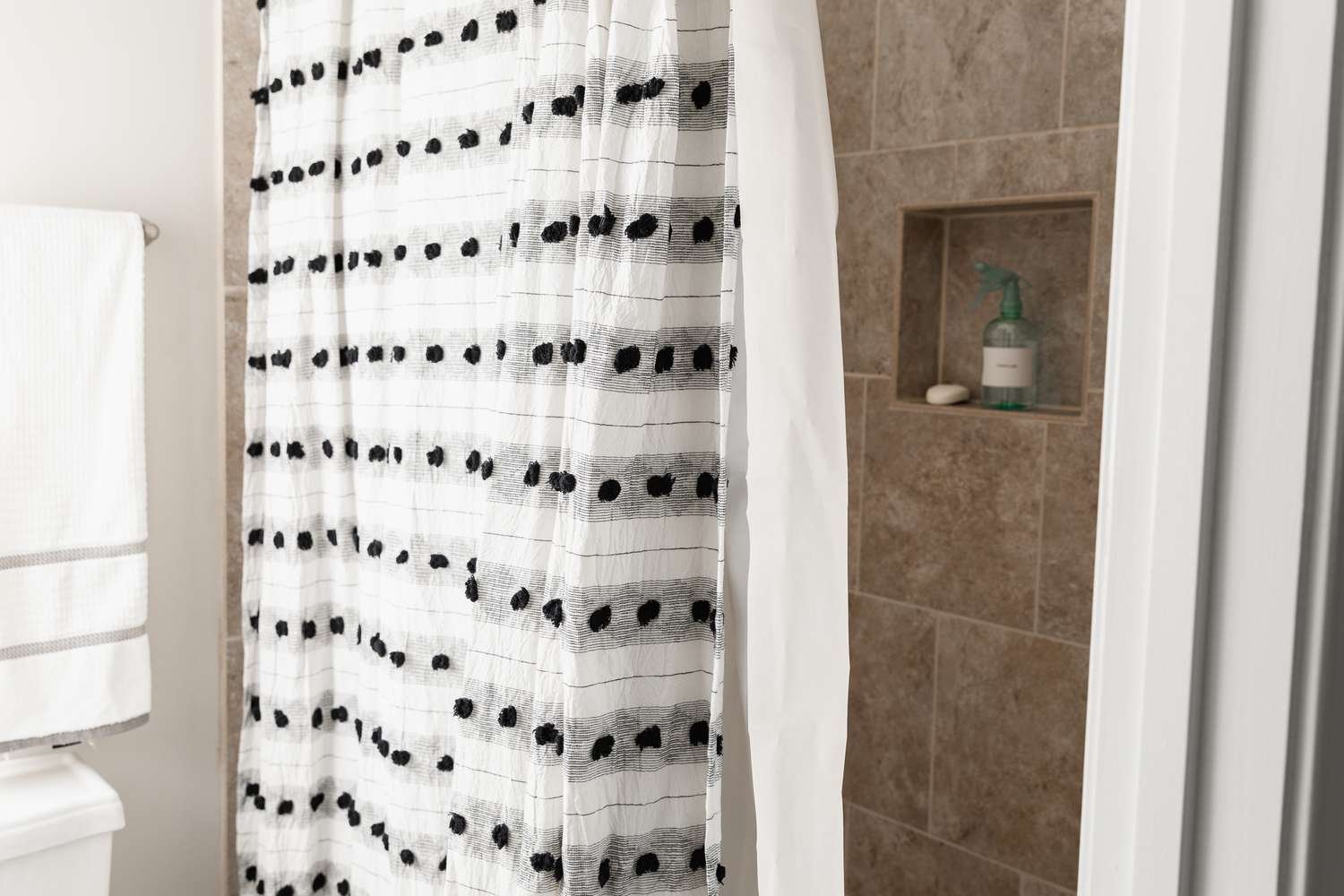 Soaking a shower curtain in oxygen bleach to remove stubborn mold stains.