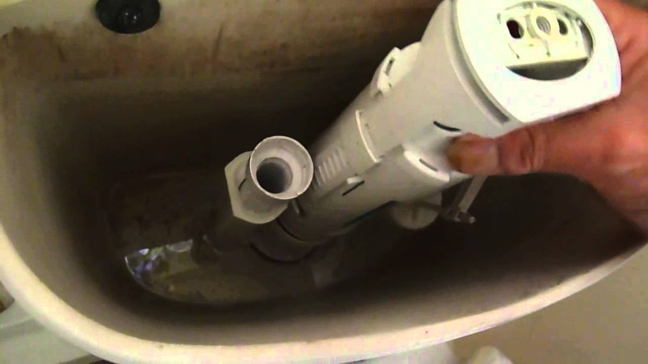 Hands removing a silicone seal from a toilet flush valve assembly.