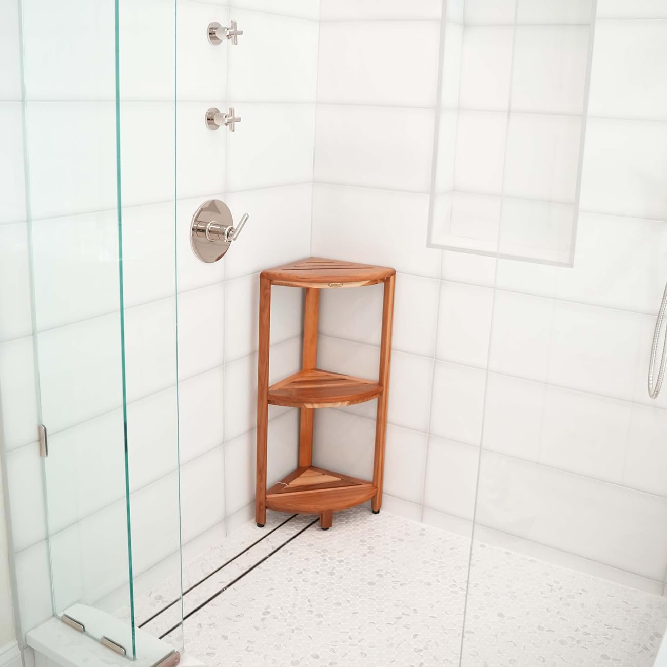 Neatly arranged toiletries on a functional corner shower caddy in a bright bathroom.