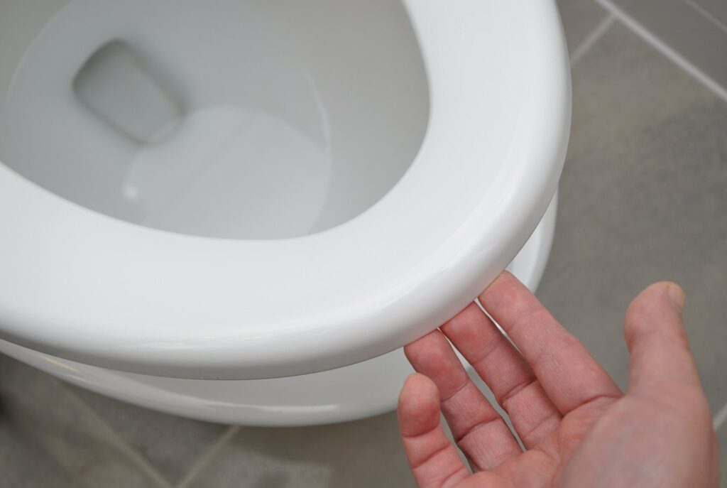 A clean modern bathroom with a closed toilet lid in soft natural light.