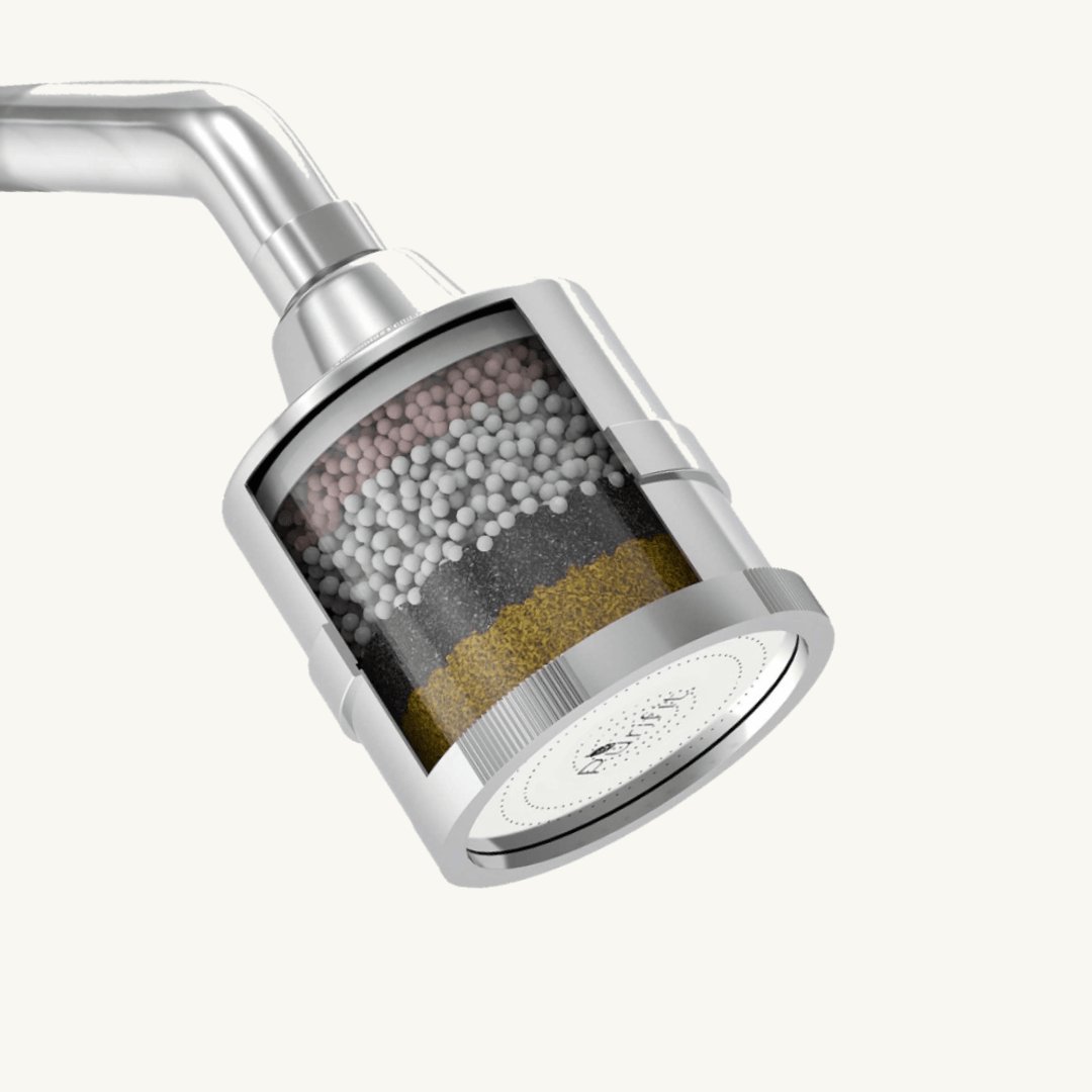 Hands performing maintenance on a shower filter by replacing a small rubber seal.