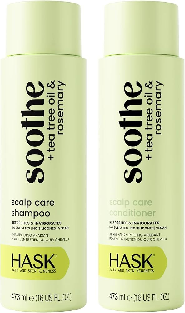 Hands lathering tea tree oil shampoo in a modern, light-filled shower environment.