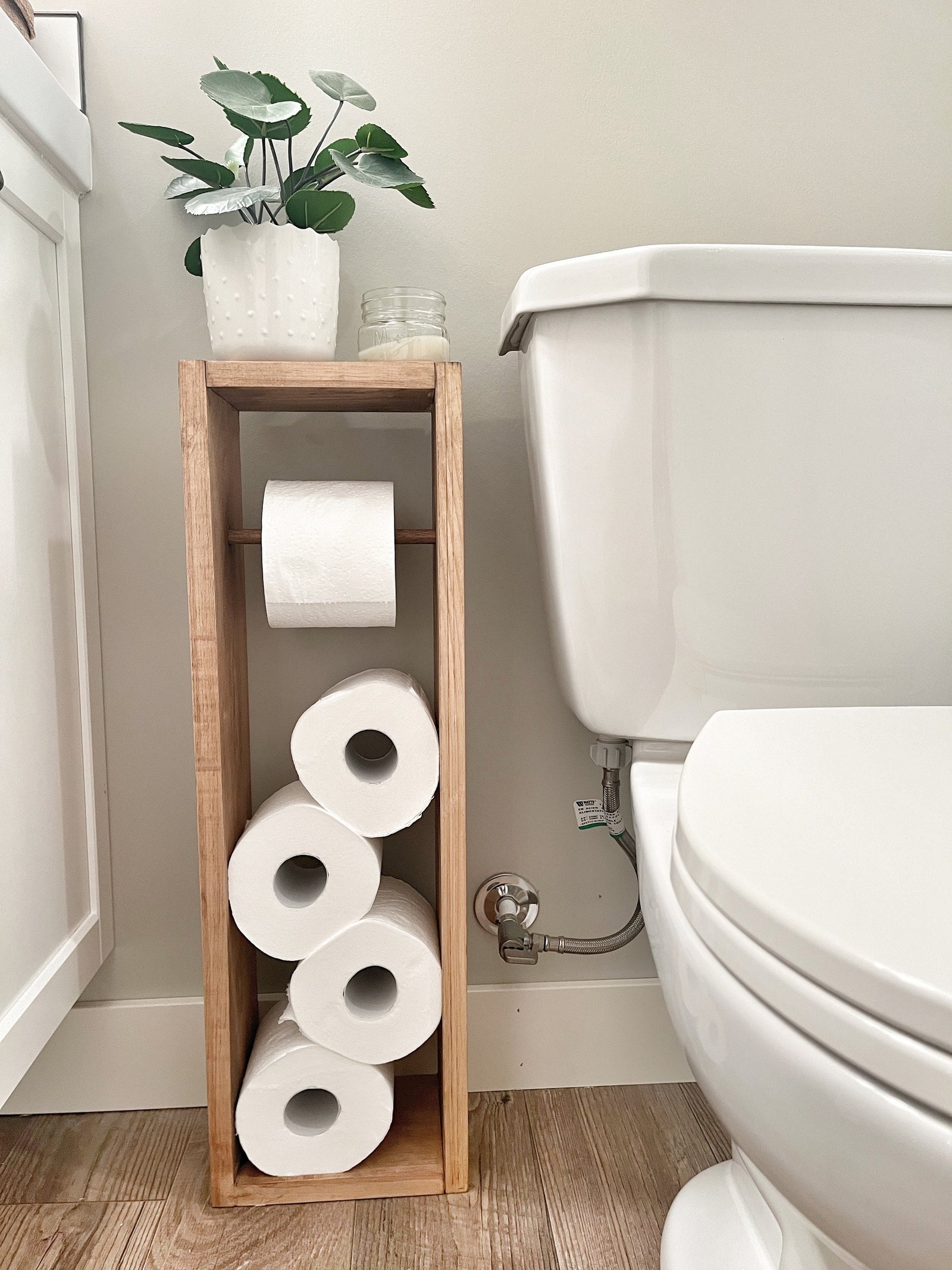 Modern bathroom setup featuring a functional toilet paper holder with a top shelf.