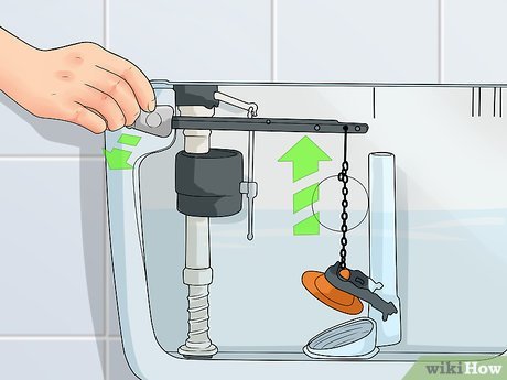 Close-up of a toilet shut-off valve and flexible supply line in a bathroom.