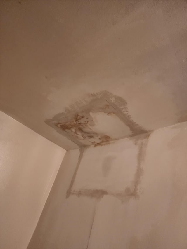 Investigating a water leak path on a ceiling to find the source.