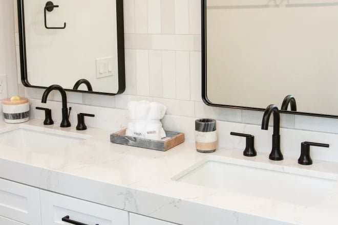 Installation of a tall vessel deck mounted faucet behind a modern ceramic bowl sink.