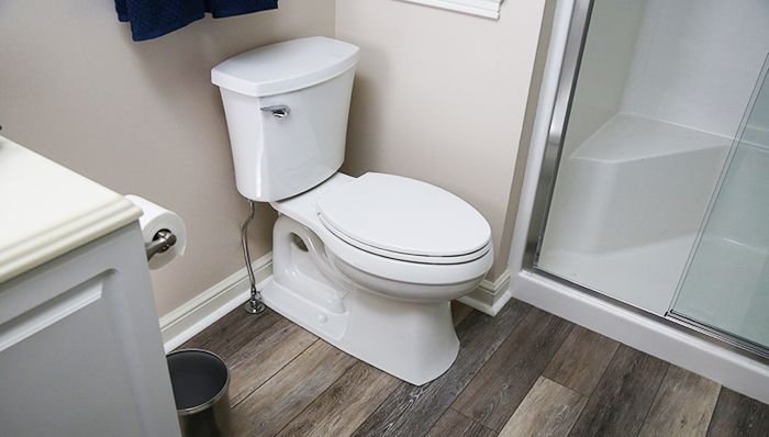 Checking for leaks around the base of a newly installed toilet.