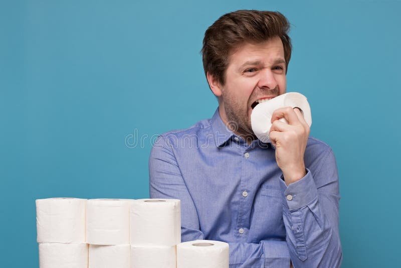 A glass of water sits next to a small piece of toilet paper.