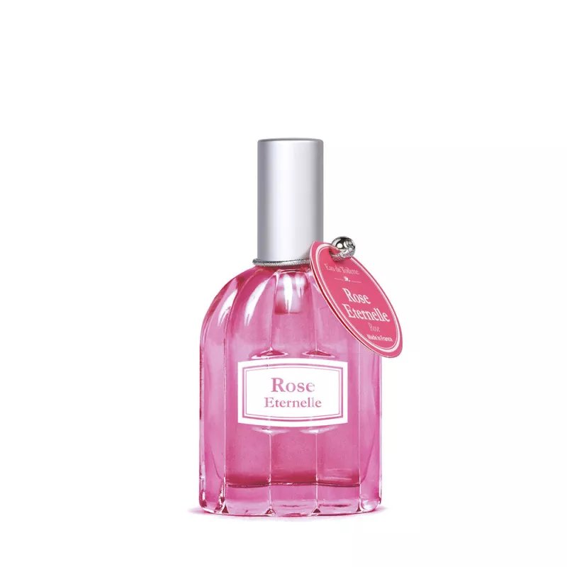 A luxury perfume bottle sits on a desk next to a notebook for researching fragrance questions.