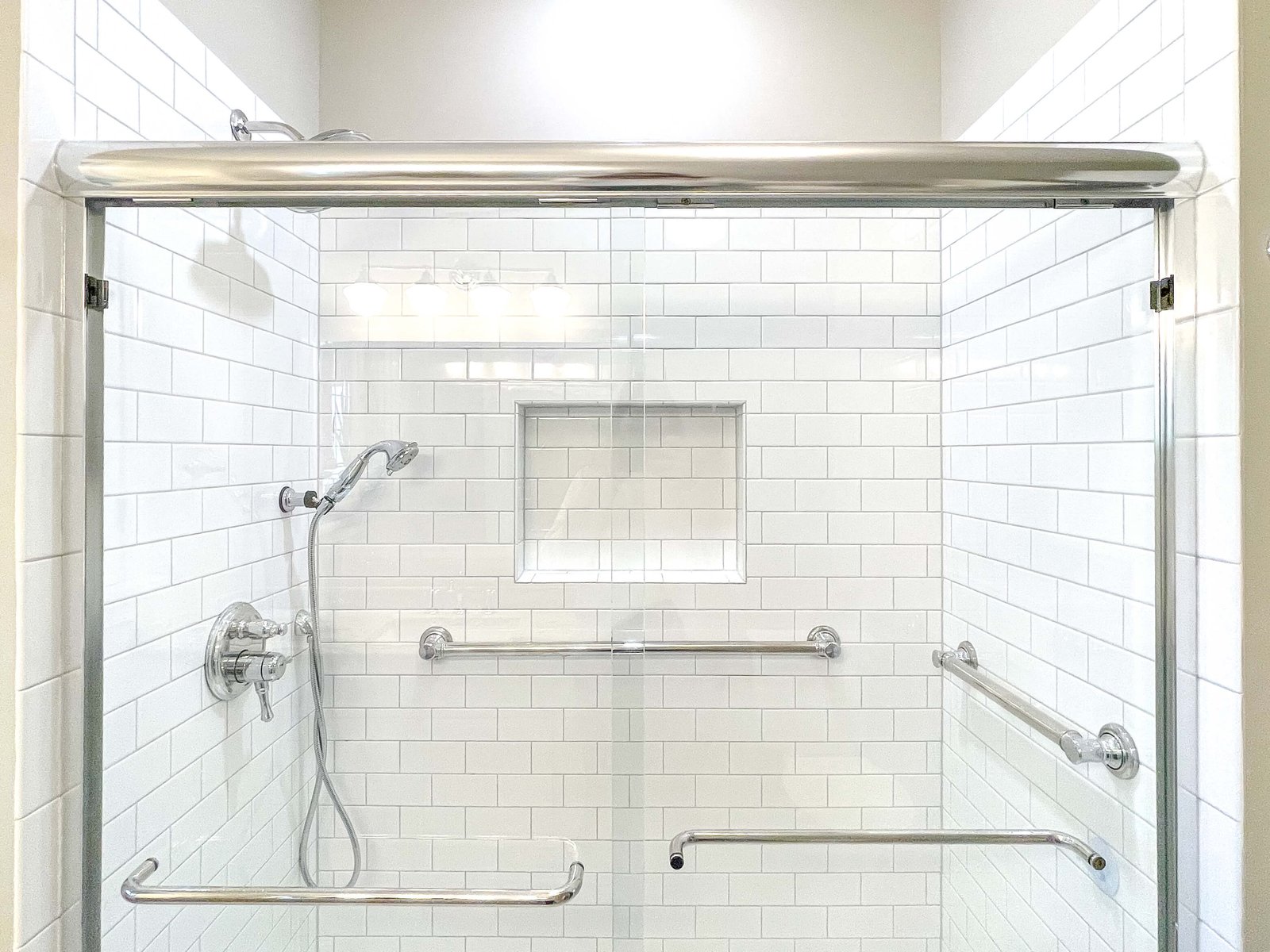 A contractor uses a stud finder to locate framing for a secure grab bar.