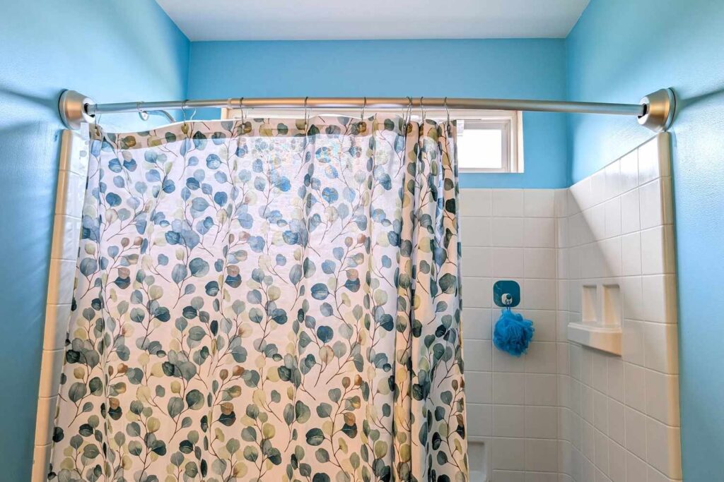A high-quality shower liner hanging in a modern bathroom with soft natural lighting.