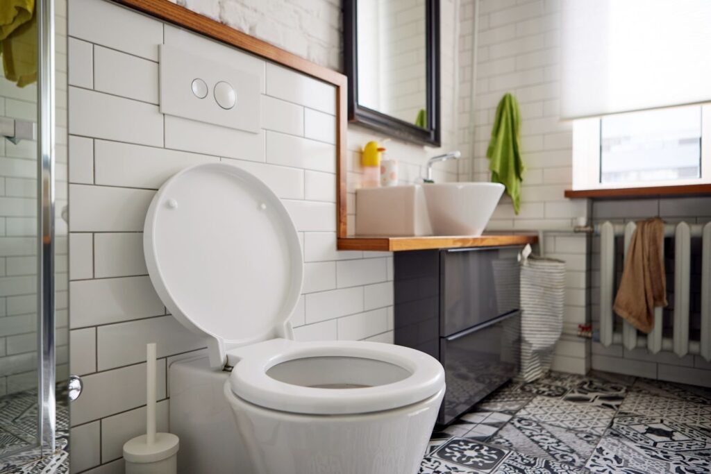 A clean modern bathroom with a white porcelain toilet under soft natural light.